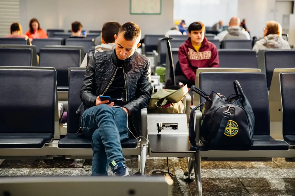 Voyageur consultant son téléphone à l'aéroport